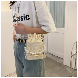 Detailed straw bucket bag with pearl handle, daisy embroidery and crossbody chain