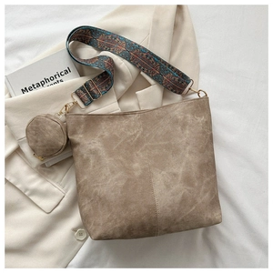 Detail of khaki suede bucket bag with ethnic patterned strap and round coin purse accessory