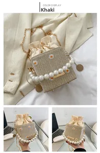 Close-up of khaki straw bucket bag featuring daisy embroidery and pearl handle detail