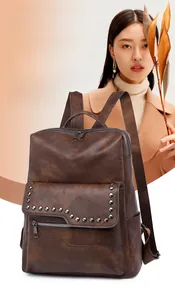 Detail of dark brown vintage faux leather backpack with metallic rivets on model