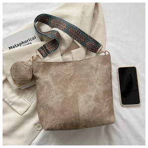 Detail of vintage bucket bag with ethnic embroidery wide strap and mini coin purse