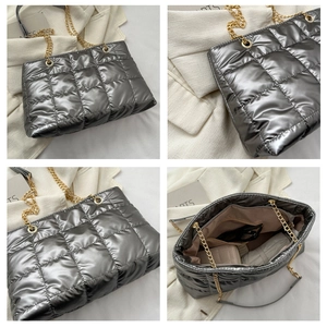 Détails intérieurs et texture matelassée du sac argenté avec chaîne dorée