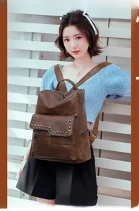 Detail of dark brown retro soft leather backpack with stylish silver rivets and pockets