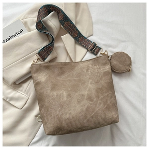 Detail of vintage bucket bag with bohemian embroidered strap and suede texture