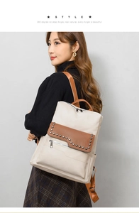 Detail of soft leather backpack with silver rivets and contrasting brown shoulder straps