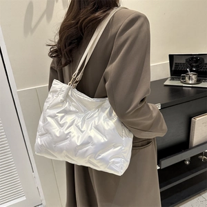Sac cabas en duvet matelassé blanc chic avec une finition brillante dans un café élégant