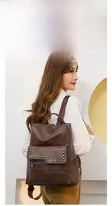 Detail view of brown vintage soft PU leather backpack with silver rivets and zippers