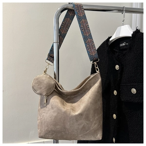 Detail of beige bucket bag with retro geometric wide strap and mini coin pouch hanging