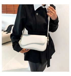 Chic cream leather shoulder bag with asymmetrical flap shown on a model for daily commute style