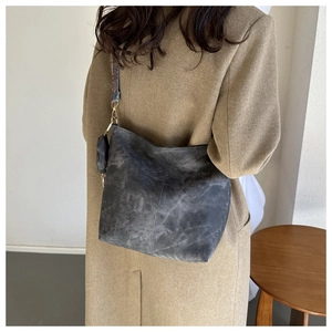 Detail of vintage gray bucket bag with blue and orange geometric woven shoulder strap