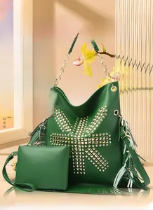 Detail of dark green bucket bag featuring golden square studs and long side tassels