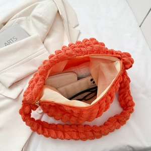 Interior view of orange bubble textured cloud bag showing storage for phone and wallet