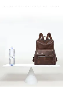 Lightweight brown vintage backpack weighing only 0.55kg shown on a creative scale balance