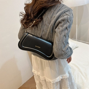 Minimalist black leather underarm bag with unique curved design and gold hardware