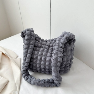 Detail of grey pleated cloud bag showing 3D bubble texture fabric and soft shoulder strap
