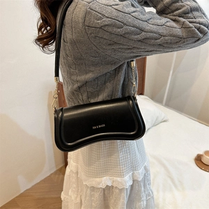Minimalist black curved underarm bag for women with gold chain and matte leather finish