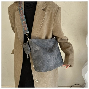 Detail of dark grey vintage bucket bag with colorful ethnic style wide strap and mini pouch