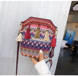 Detail of bohemian bucket bag featuring ethnic woven patterns and colorful tassels