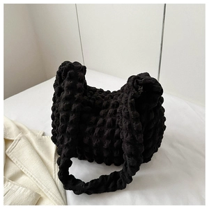 Detail of black popcorn fabric texture on a soft shoulder bag with bubbly 3D tactile surface