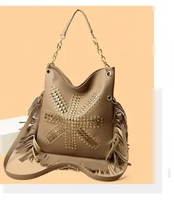 Macro detail of khaki boho shoulder bag with golden studs and long decorative fringes