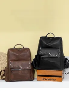 Detail of vintage soft leather backpacks in dark brown and black with rivet accents