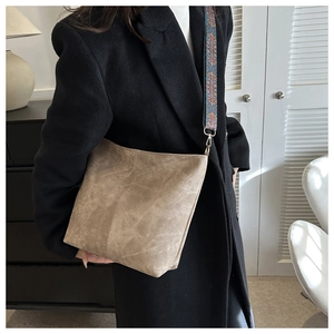 Brown vintage bucket bag with ethnic style wide woven shoulder strap shown on model