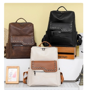 Three minimalist soft leather backpacks in brown, black, and beige with rivet detail