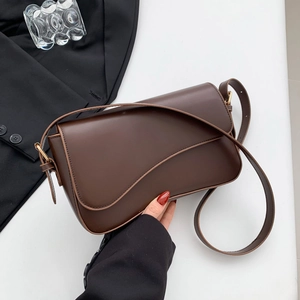 Minimalist dark brown crossbody bag with wave flap design and gold hardware buckle