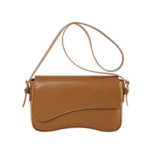 Minimalist caramel brown leather crossbody bag with curved flap and golden metal buckle