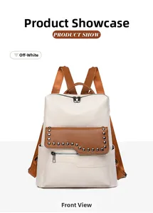 Detail view of the beige faux leather backpack with brown trim and metal rivet accents