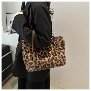 Detail of plush leopard print tote bag with faux leather strap and metal chain links
