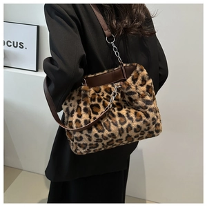 Macro shot of fluffy leopard print tote bag with brown leather strap and chain detail
