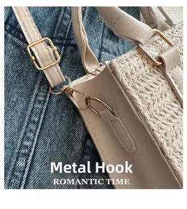 Gros plan sur les crochets dorés et la texture tressée d'un sac paille beige