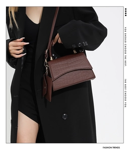 Détails d'un sac à main marron foncé à motif crocodile avec garnitures dorées