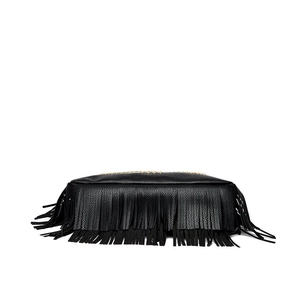 Close-up of black fringe tassels and gold zipper hardware on a pebbled leather shoulder bag