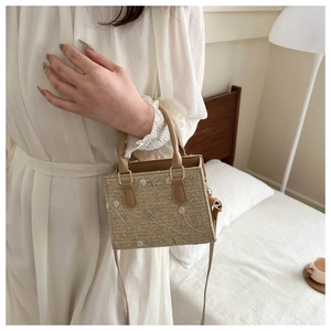 Détail du sac cabas en paille avec broderies florales et poignées en cuir en intérieur