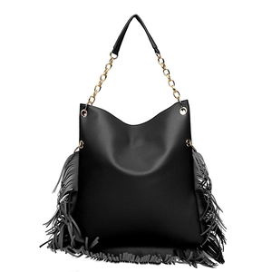 Close-up of black lychee grain leather tote bag featuring long fringes and gold chain strap