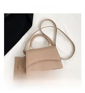 Détail du sac à main marron clair effet croco avec poignée tressée et mini pochette