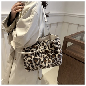 Detail view of leopard print plush tote bag with leather strap and metal chain trim