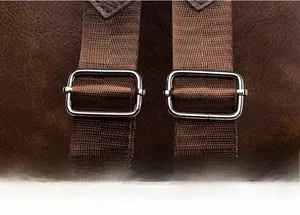 Detail of adjustable dark brown textile strap with silver metal buckle on leather backpack