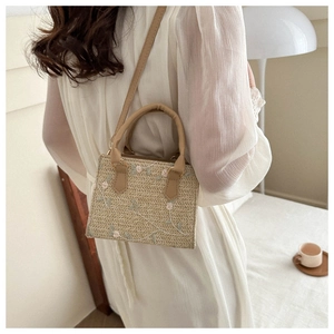 Détail du sac carré en paille avec broderie florale et bandoulière en similicuir