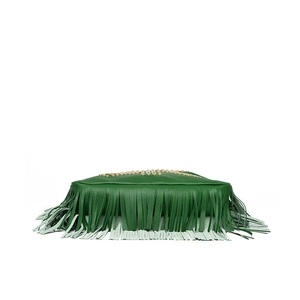 Detailed view of green leather bag featuring long tassels and gold metal rivet accents