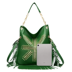 Green fringe crossbody bag with gold punk studs shown next to an iPad for size comparison