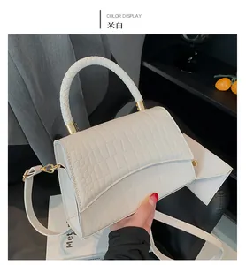 Détail du sac à main blanc cassé avec motif crocodile, anse tressée et mini pochette