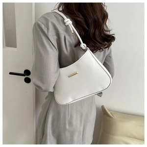 Detail of white half-moon shoulder bag with gold clasp and knotted leather strap
