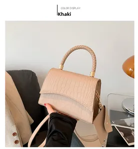 Détail du sac kaki effet crocodile avec poignée tissée et finitions métalliques dorées