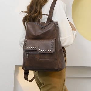 Vintage brown leather backpack for women with silver stud rivets shown on a model