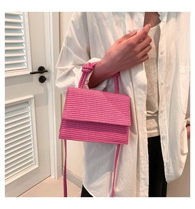 Detail of pink woven crossbody bag showing textured finish and matching handle