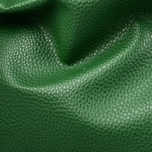 Detailed close-up of forest green pebble grain leather texture on large shoulder bag