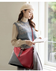 Detail of red pebbled leather and houndstooth patchwork tote with silver zipper tassel